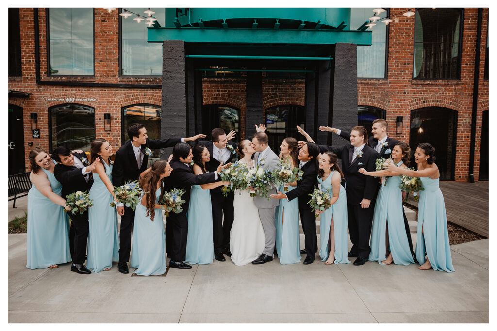 Congdon Yards Outside bridesmaids and groomsmen surrounding couple