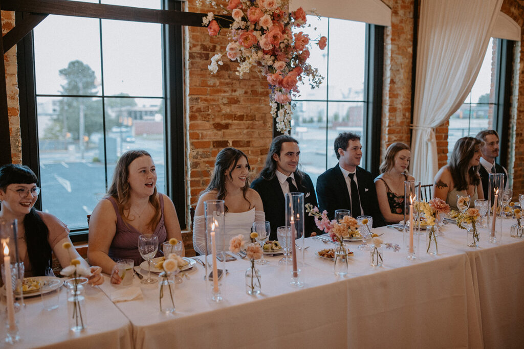 Congdon Yards Pine Room at the Loft head table at wedding reception laughing