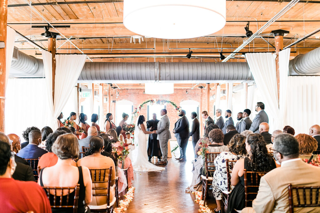 Congdon Yards Pine Room at the Loft wedding ceremony holding hands