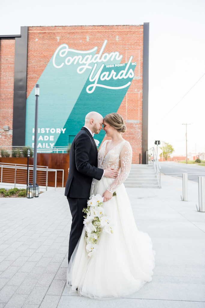 congdon yards courtyard bride and groom embrace in front of mural