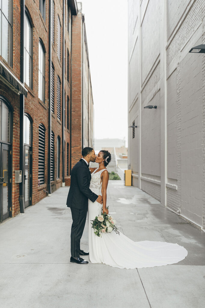 congdon yards courtyard bride and groom kiss in alley