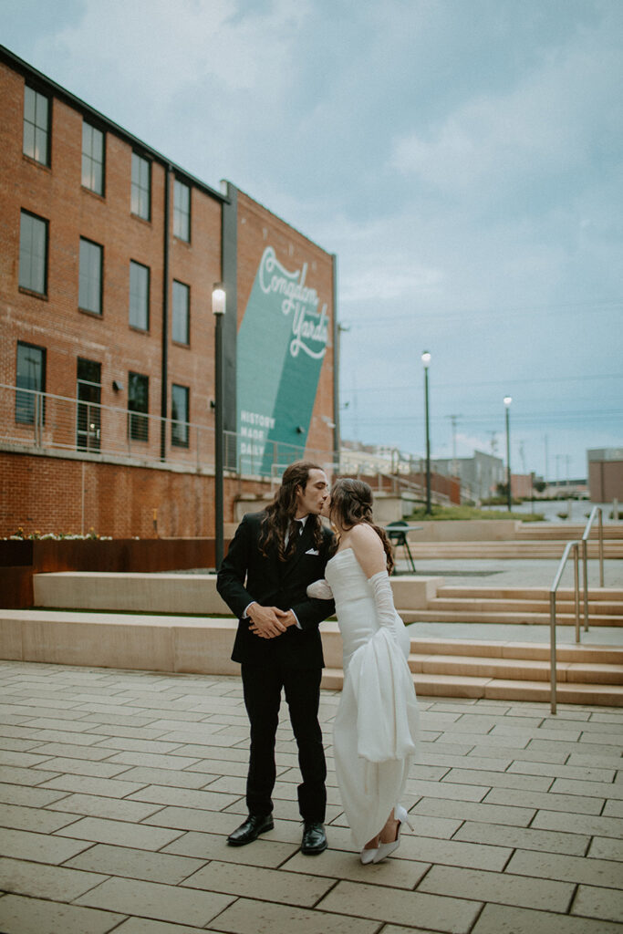 congdon yards courtyard bride and groom kiss in rain