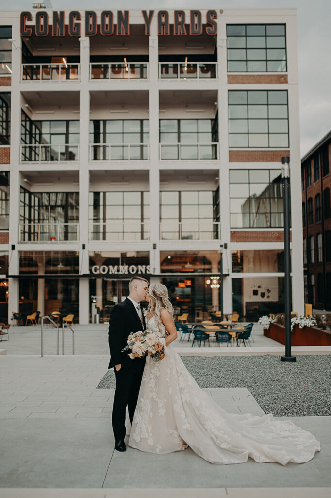 congdon yards courtyard bride and groom kissing in front of plant seven