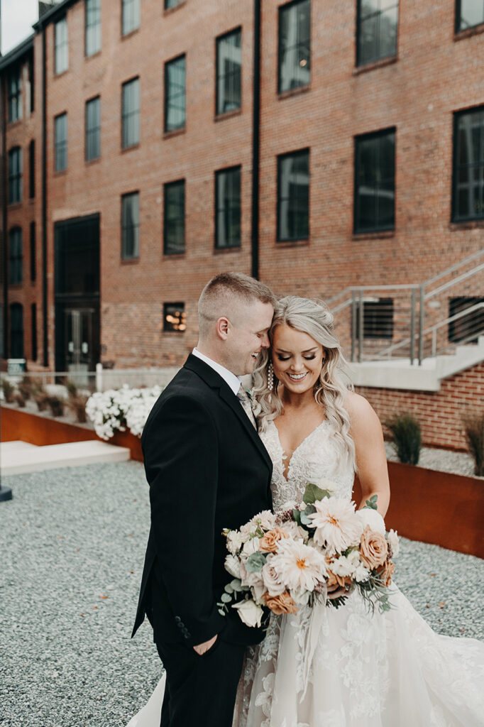 congdon yards courtyard bride and groom posing with bouquet