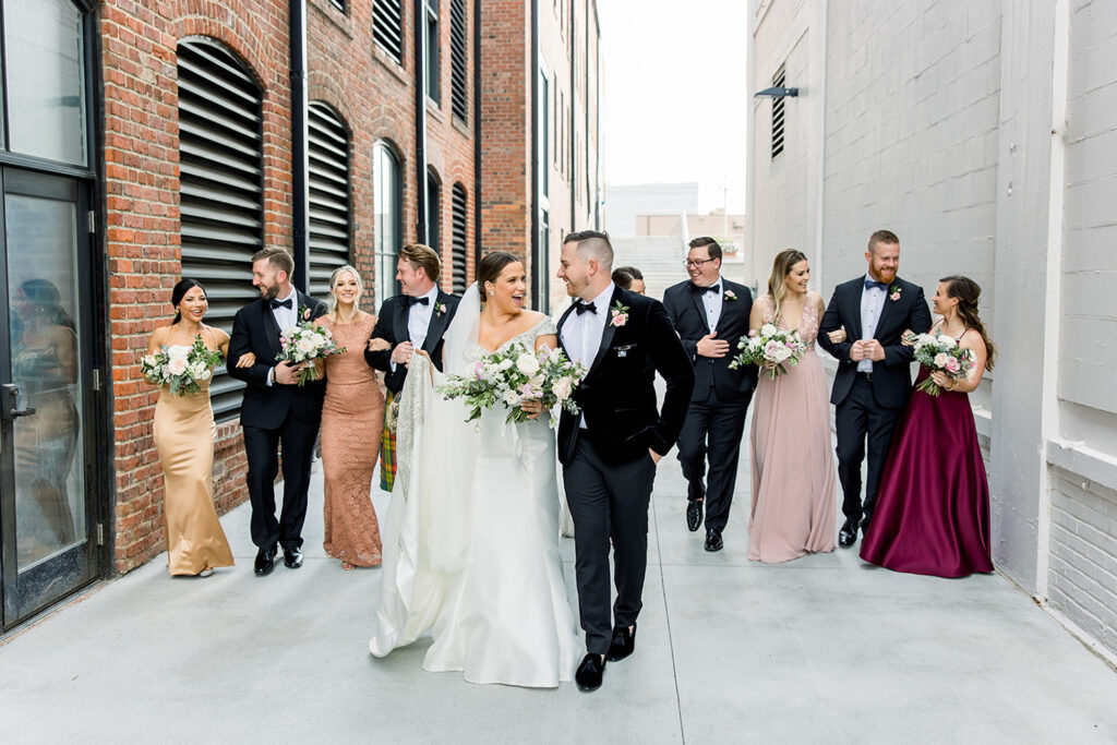 congdon yards courtyard bride and groom walk in front of bridal party