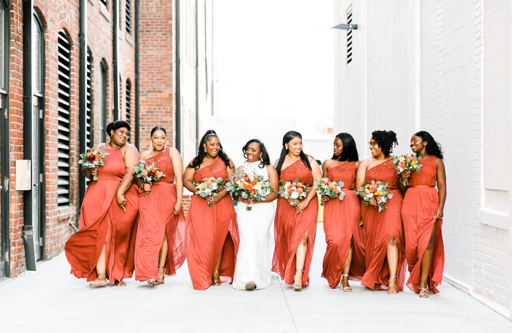 congdon yards courtyard bride walking with lots of bridesmaids