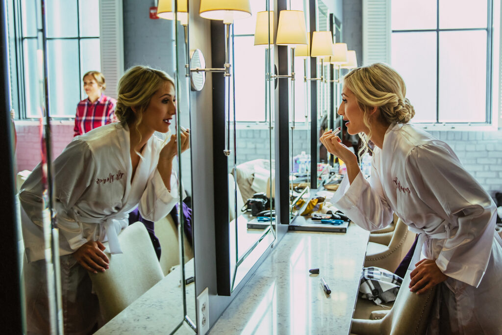 congdon yards luxe suite bride putting on lipstick looking in mirror