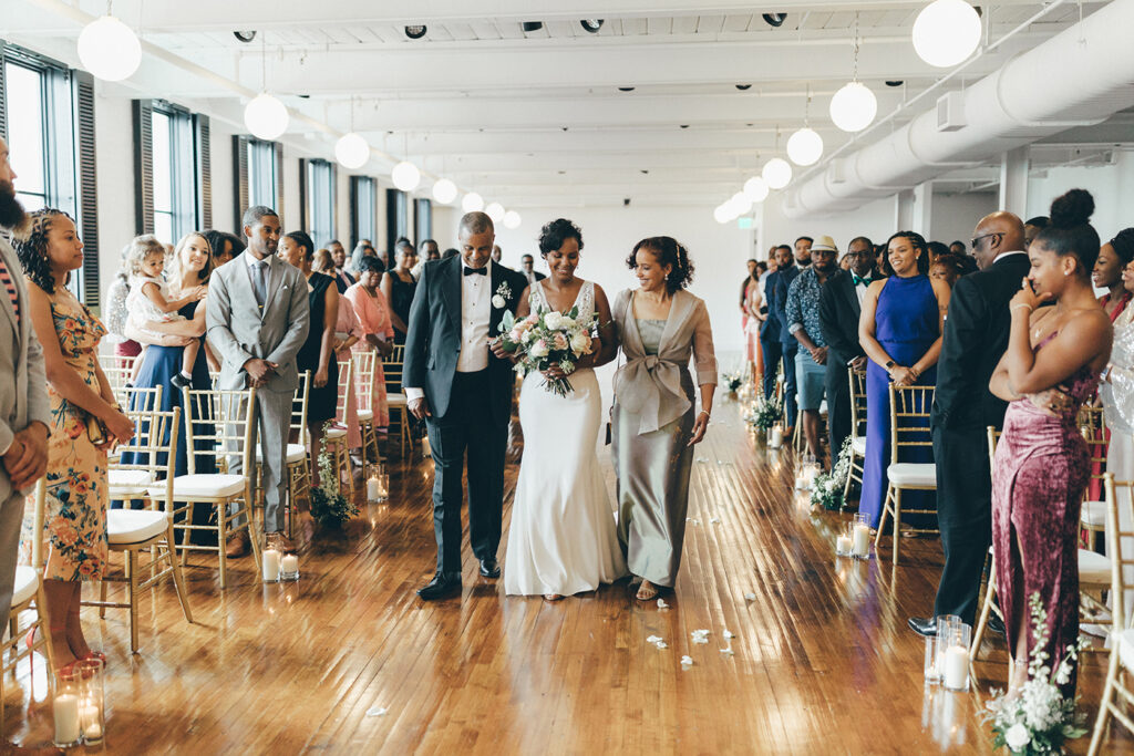 congdon yards silk room at the loft bride walking down aisle with parents