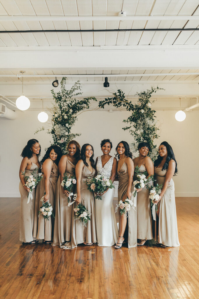 congdon yards silk room at the loft bridesmaids smiling in front of backdrop