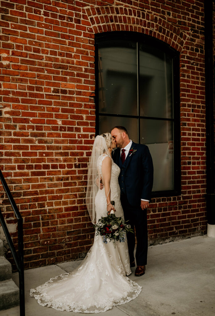 congdon yards the factory bride and groom kiss in historic wedding venue